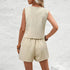 Woman wearing a beige sleeveless top and shorts set against a light gray background
